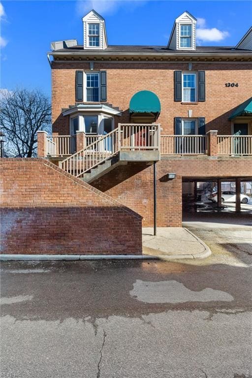 view of front facade with stairs and brick siding