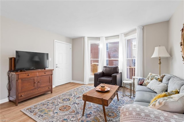 living room with light wood-style flooring and baseboards