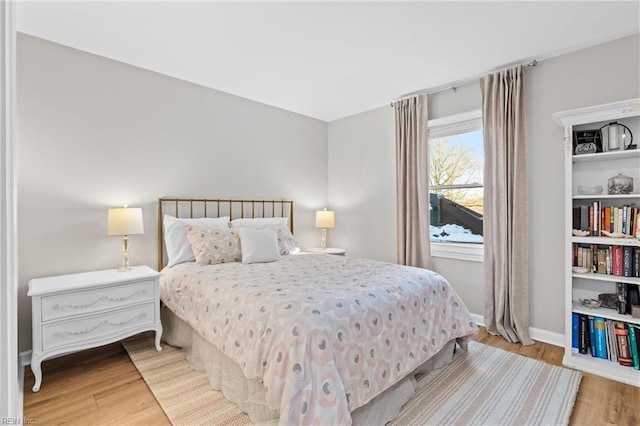 bedroom featuring baseboards and wood finished floors