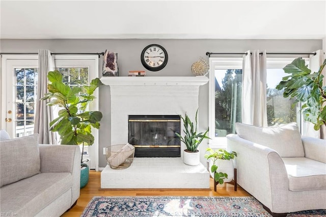 living area featuring wood finished floors and a glass covered fireplace