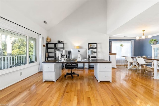 office space with a chandelier, a healthy amount of sunlight, and light wood finished floors