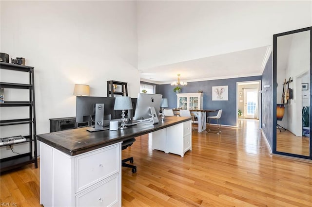 home office with light wood-style floors, crown molding, baseboards, and a notable chandelier