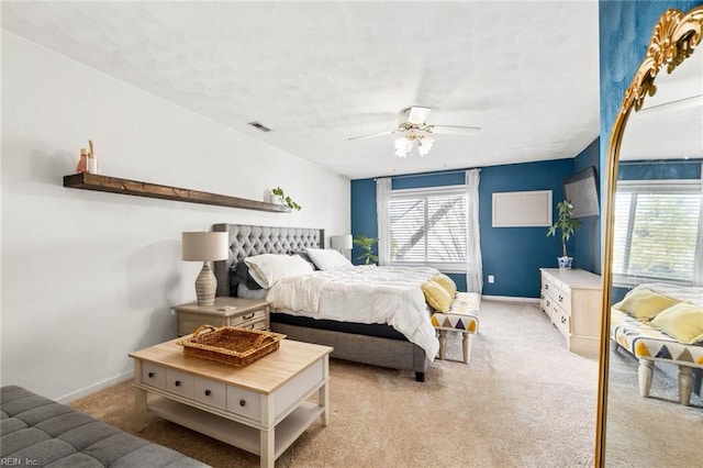 bedroom featuring baseboards, visible vents, and light colored carpet