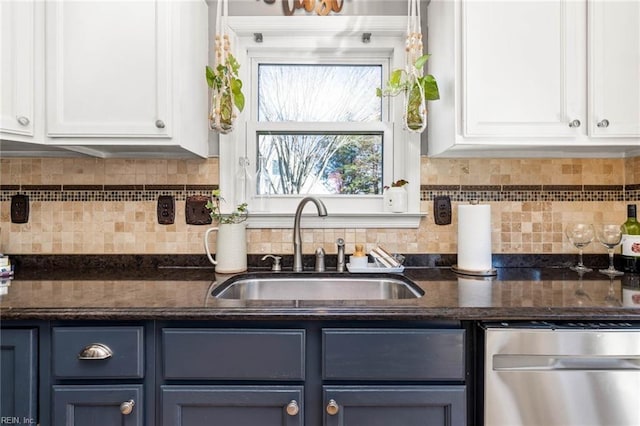 kitchen featuring stainless steel dishwasher, white cabinetry, backsplash, and a sink