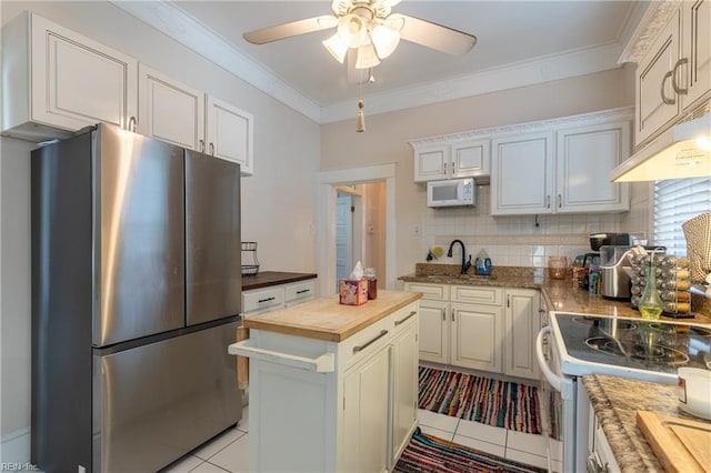 kitchen with crown molding, white appliances, butcher block countertops, and white cabinets