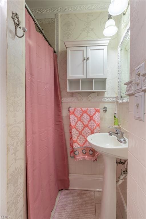 bathroom featuring a shower with shower curtain, tile patterned flooring, and wallpapered walls