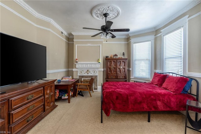 bedroom featuring light carpet, ornamental molding, and a ceiling fan