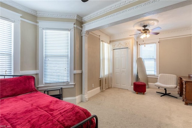 bedroom featuring light carpet, crown molding, a ceiling fan, and baseboards