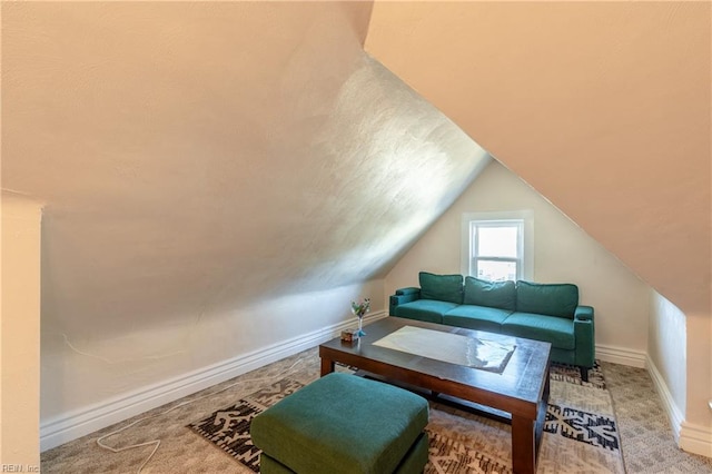 living room featuring carpet floors, lofted ceiling, and baseboards