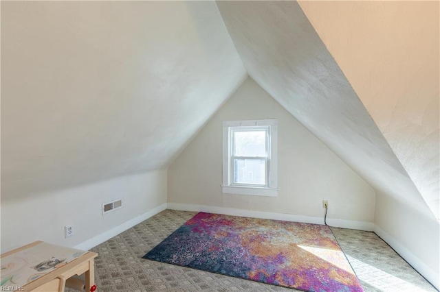 additional living space featuring lofted ceiling, visible vents, light carpet, and baseboards