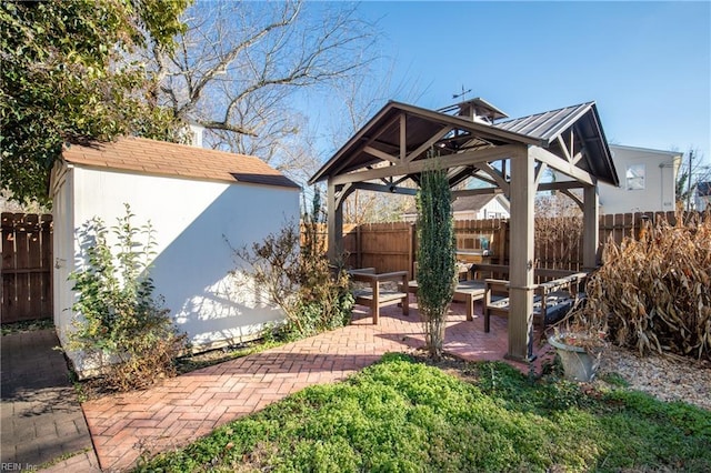 view of patio / terrace with a storage shed, a gazebo, an outdoor structure, and fence