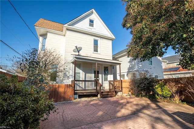 view of front facade featuring a porch and fence