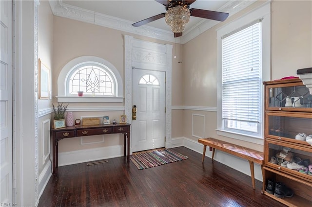 foyer entrance with a wainscoted wall, plenty of natural light, ornamental molding, and wood finished floors