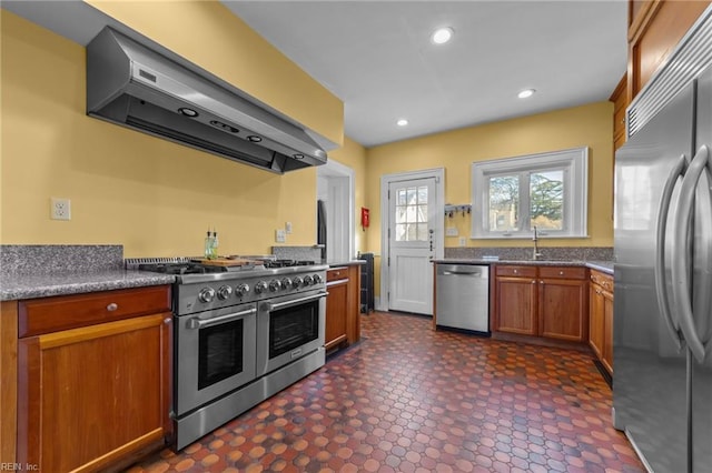 kitchen with dark floors, stainless steel appliances, under cabinet range hood, a sink, and recessed lighting