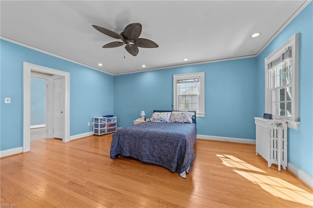 bedroom featuring baseboards, ornamental molding, wood finished floors, and radiator