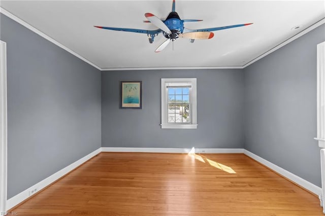 empty room featuring baseboards, ornamental molding, and wood finished floors