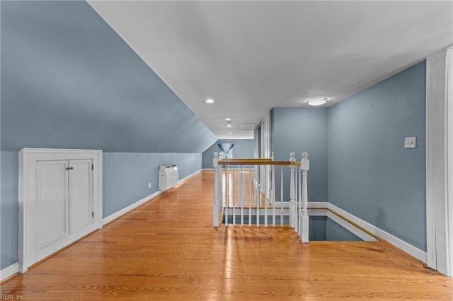 additional living space with lofted ceiling, baseboards, wood finished floors, and recessed lighting