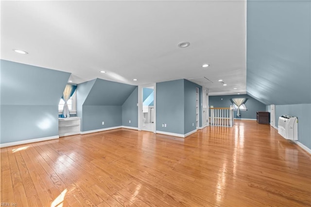 additional living space with lofted ceiling, baseboards, light wood finished floors, and recessed lighting