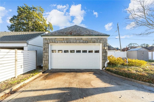 detached garage featuring fence