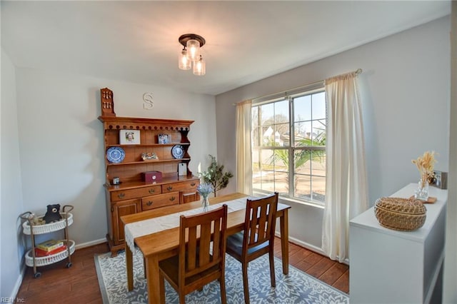 dining space featuring dark wood finished floors and baseboards