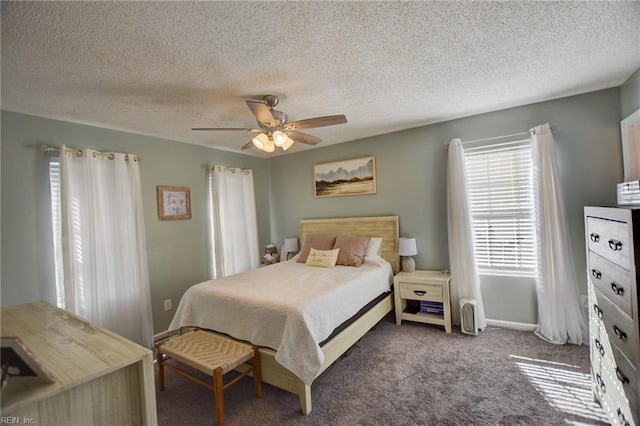 bedroom with a textured ceiling, dark carpet, and a ceiling fan