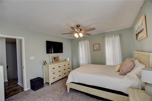 bedroom with a textured ceiling, carpet floors, a ceiling fan, and baseboards