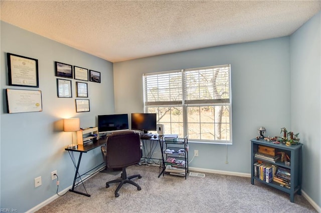 carpeted home office with a textured ceiling and baseboards