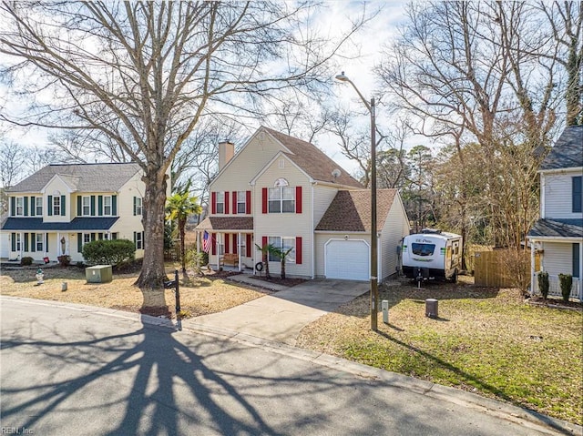 view of front of property featuring a chimney, an attached garage, a front yard, fence, and driveway