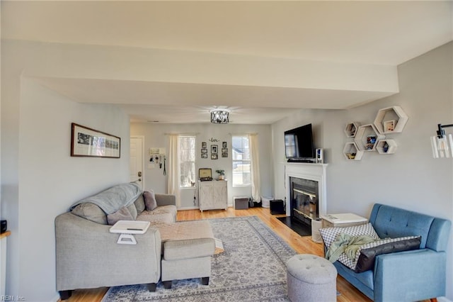 living room with a fireplace with flush hearth and light wood finished floors