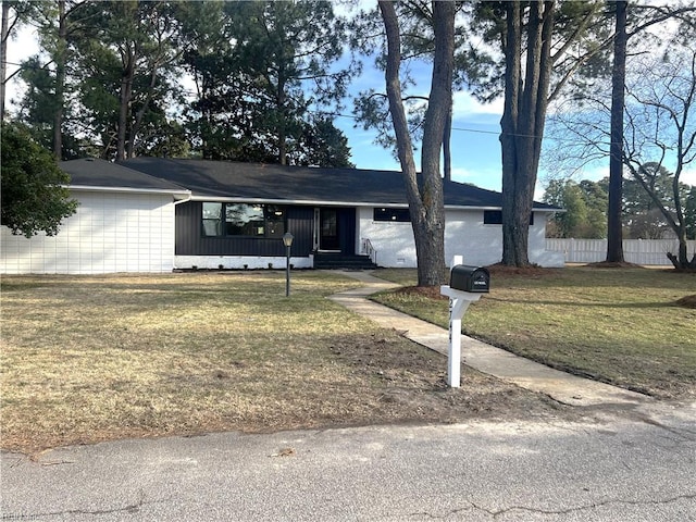 ranch-style house featuring fence and a front yard