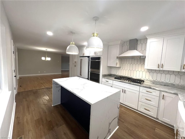 kitchen featuring stainless steel appliances, a center island, wall chimney exhaust hood, tasteful backsplash, and dark wood finished floors