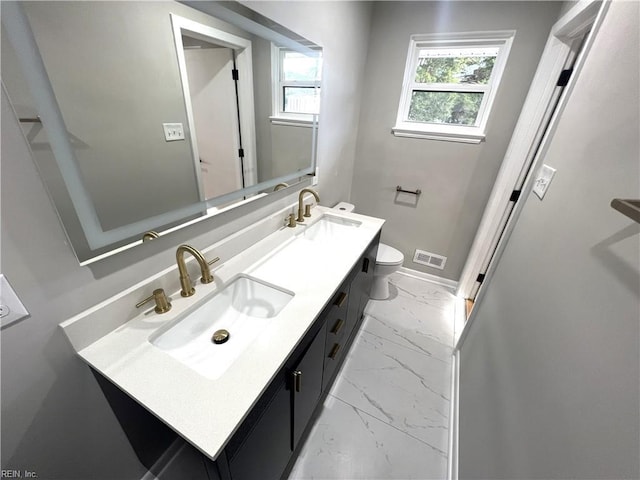 bathroom featuring toilet, marble finish floor, a sink, and visible vents