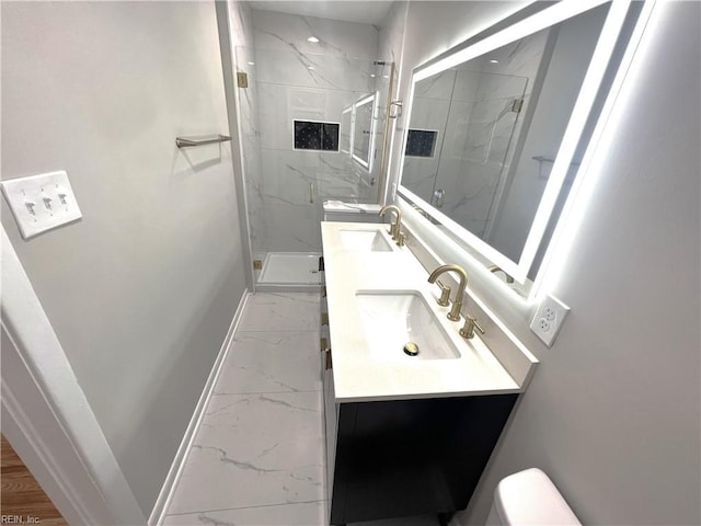 full bath with marble finish floor, a sink, a marble finish shower, and baseboards