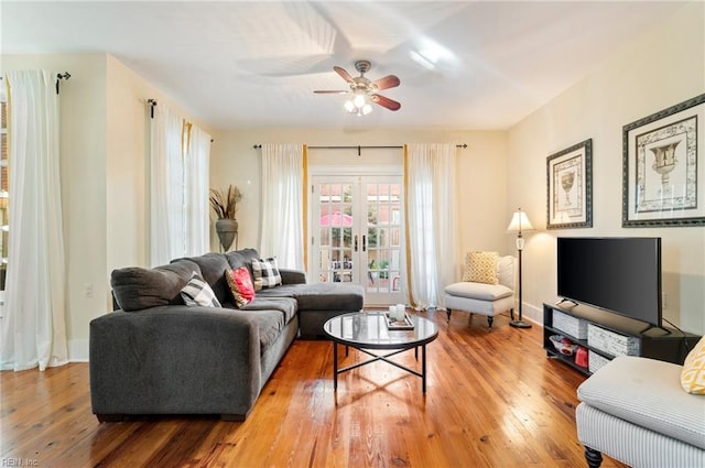 living room featuring a ceiling fan, french doors, baseboards, and hardwood / wood-style floors