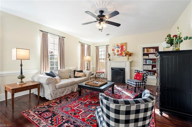 living room featuring plenty of natural light, a fireplace, dark wood finished floors, and ceiling fan