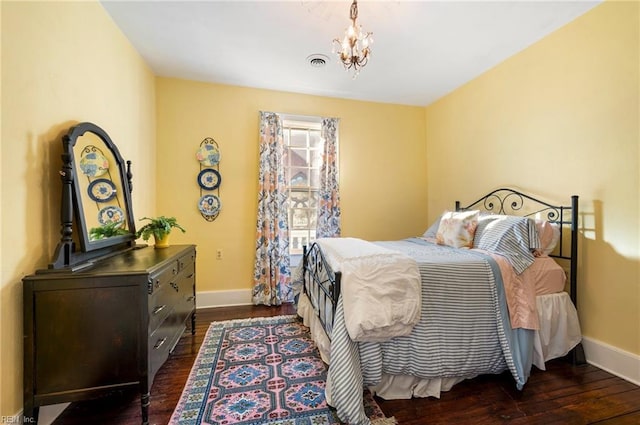 bedroom featuring a notable chandelier, dark wood finished floors, visible vents, and baseboards