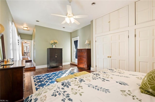 bedroom featuring ceiling fan, dark wood-type flooring, a closet, and baseboards