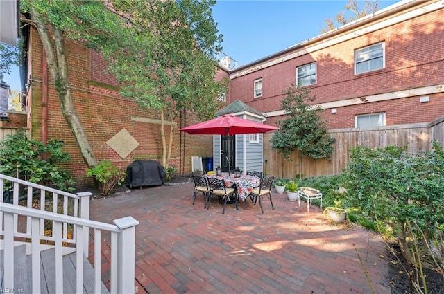 view of patio featuring outdoor dining area, a grill, and fence