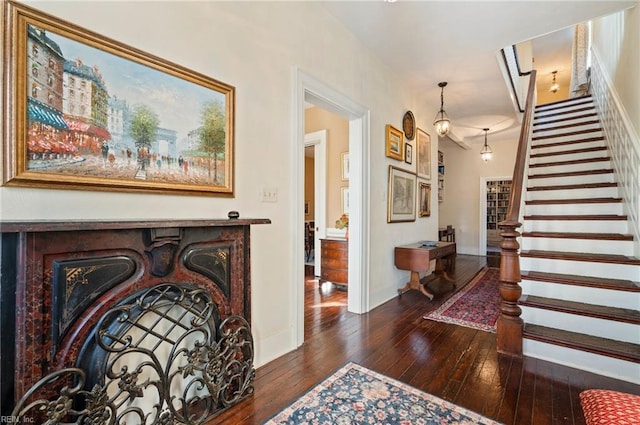 entrance foyer featuring a fireplace, stairway, baseboards, and hardwood / wood-style flooring