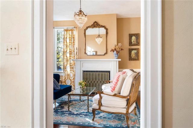 living area with a fireplace with flush hearth and a chandelier