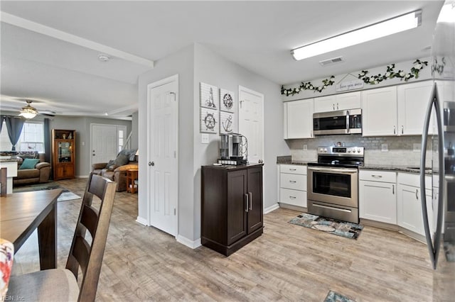 kitchen featuring visible vents, white cabinetry, appliances with stainless steel finishes, backsplash, and light wood finished floors