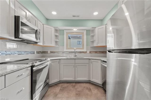 kitchen featuring visible vents, a sink, stainless steel appliances, open shelves, and backsplash