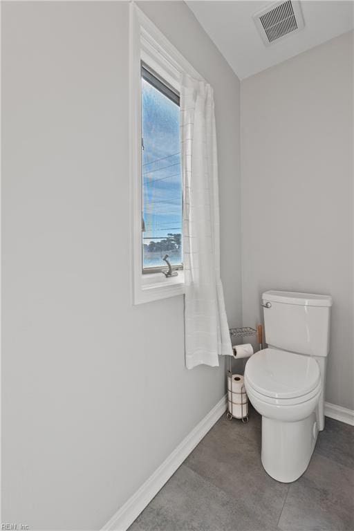 bathroom featuring toilet, visible vents, and baseboards