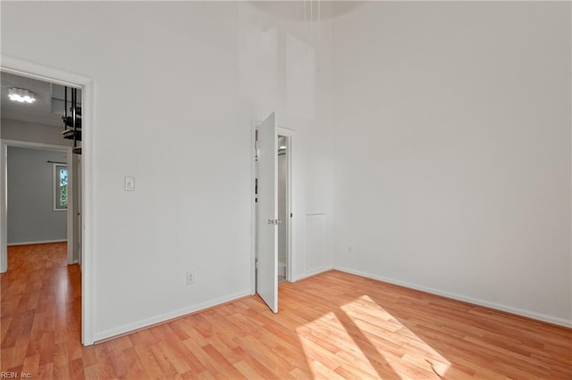 spare room with light wood-style floors and baseboards