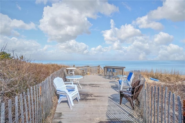 wooden deck with a water view and a view of the beach