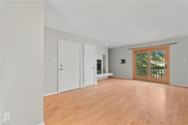 unfurnished living room with light wood-style floors and baseboards