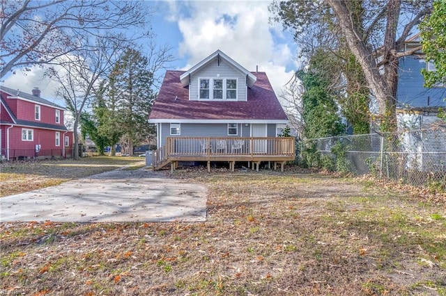 back of property with fence and a wooden deck