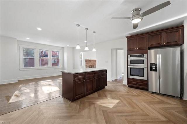 kitchen with dark brown cabinetry, stainless steel appliances, a kitchen island, baseboards, and pendant lighting