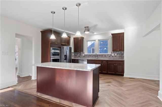 kitchen with baseboards, decorative backsplash, stainless steel appliances, and a sink