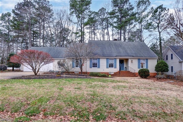 view of front of property featuring a garage, a front yard, driveway, and a shingled roof